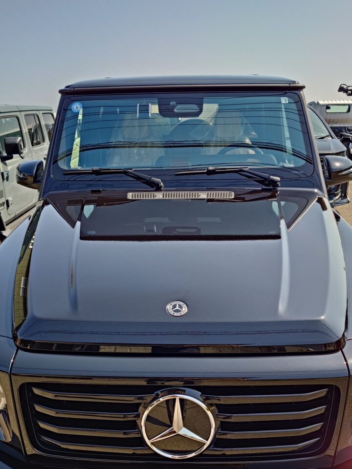 Front view of a black Mercedes-Benz van with a prominent grille and emblem in a parking lot