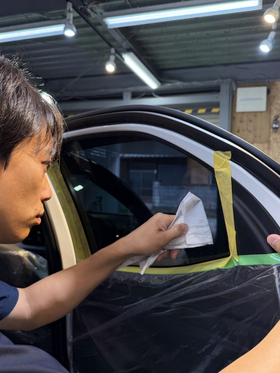窓の端まで水を抜いて仕上げるスタッフ